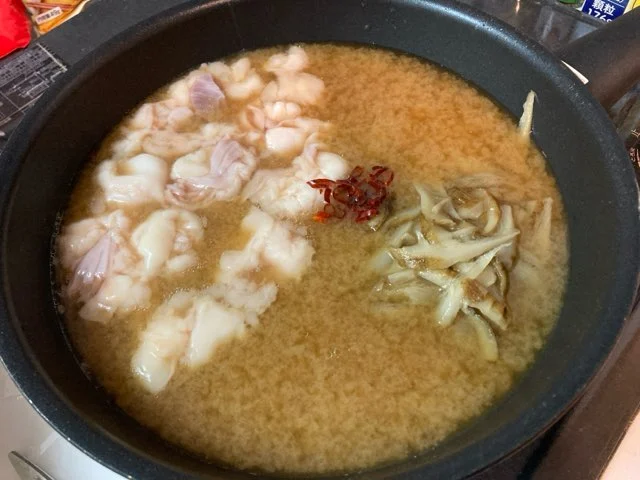 スープにもつ、ごぼう、鷹の爪を入れて火にかける